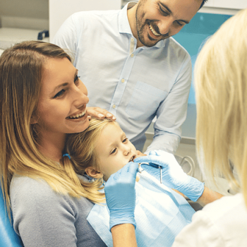 Dental blog: mom holding child in dentist chair